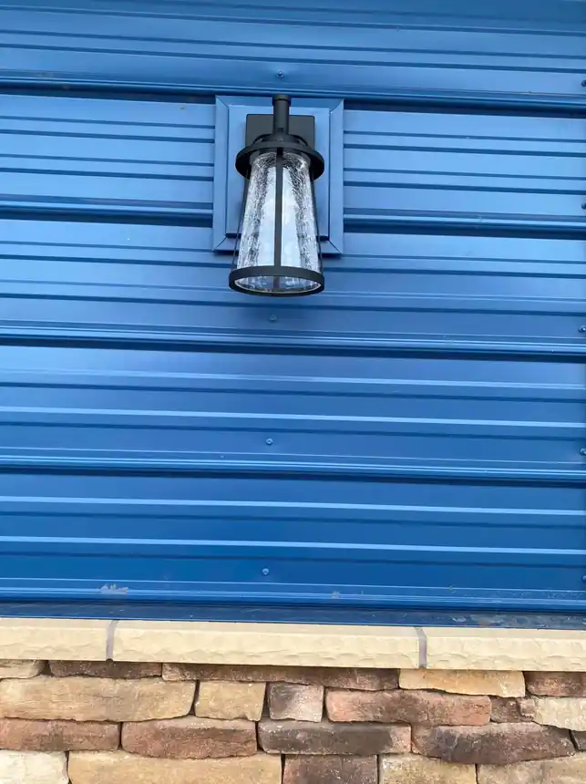 Blue metal wall panel over stone