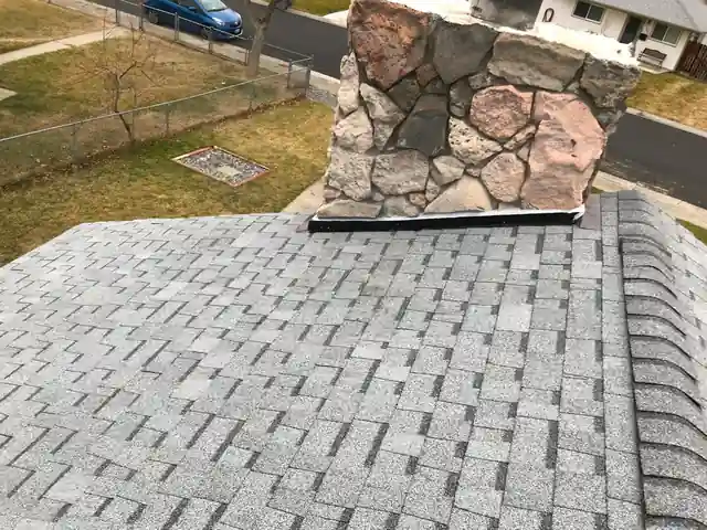 Light shingles around a fieldstone chimney
